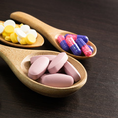 Colorful tablets and dietary supplement cod liver oil with capsules and with panels drug spilling out of a bottle, healthcare and medicine medication cure