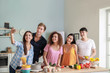 © Pixel-Shot - Happy friends taking selfie while cooking together in kitchen
