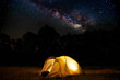 © soleg - Traveling and camping concept - camp tent at night under a sky full of stars. Orange illuminated tent. Beautiful nature - field, forest, plain. Moon and moonlight