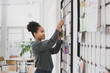 © ReeldealHD images - African American businesswoman pinning notice on board