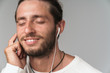 © Drobot Dean - Close up of a smiling young man enjoys listening to music
