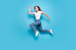 canvas print picture - Full body photo of charming sporty lady running training jogging wearing white t-shirt denim jeans isolated over blue background