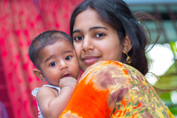 Wall Mural - A young mother and baby looking at camera.