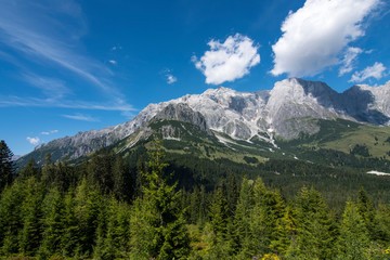 Hiking in Hochkonig (Austria) between the snowy and green mountains of the Austrian Alps