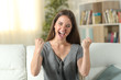 © Antonioguillem - Excited woman looking at camera sitting at home