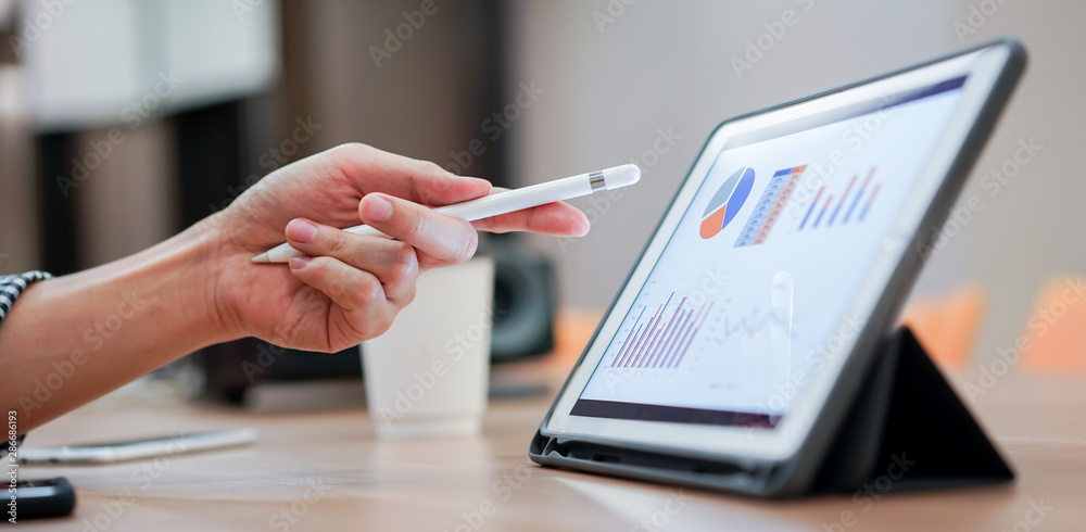 close up salesman employee hand using stylus pen to pointing on tablet screen to show company profit monthly in the meeting event at conference room , business strategy concept - obrazy, fototapety, plakaty 