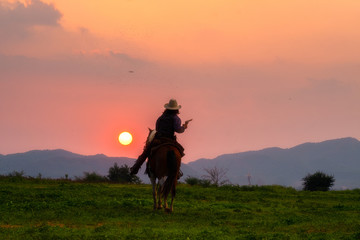 Wall Mural - silhouette of a rider on horse back in sunset