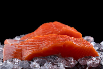 Wall Mural - Uncooked salmon filet in ice on dark  background. Raw salmon fillet. Copy space