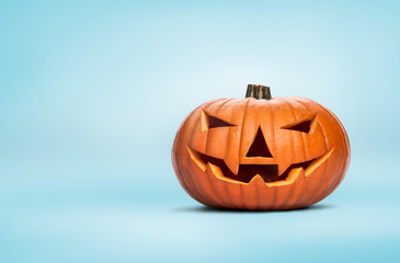 Wall Mural - A closeup of an unlit Halloween Jack O Lantern isolated on a pale blue background