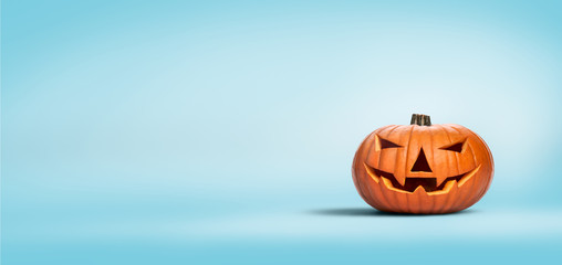 Wall Mural - An unlit Halloween Jack O Lantern isolated on a widescreen pale blue background