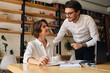 © Anton - Young attractive business colleagues joyfully looking at each other working on new project together in office
