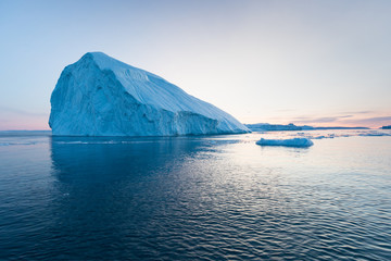 photogenic and intricate iceberg under an interesting and blue sky during sunset. effect of global w