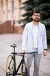 © F8  \ Suport Ukraine - Confident young businessman walking with bicycle on the street