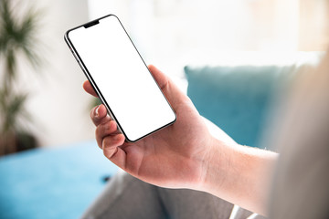 Man using smartphone blank screen frameless modern in home interior