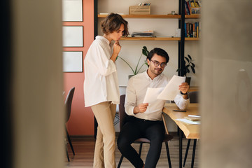 Aufkleber - Young attractive business colleagues thoughtfully reading papers at work in office