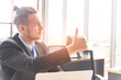 © Arunporn - Successful and confidence concept. Young smiling business man showing thumb up or like looking forward to the future