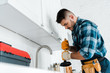 © LIGHTFIELD STUDIOS - selective focus of repairman holding plunger in kitchen