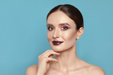 Poster - Beautiful young woman with glitter makeup on blue background