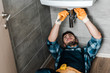 © LIGHTFIELD STUDIOS - selective focus of repairman fixing water damage with wrench in bathroom