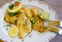 Fried Plaice Fillet With Herb Butter And Lemon On A Plate, Typical Food In Northern Germany At The Coast, High Angle View, Above