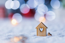 Wooden Icon Of House With Hole In Form Of Heart With Red Home Christmas Decor And Blurred Bokeh Background In Daylight.