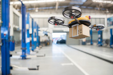 Spare Part Delivery Drone At Garage Storage In Leading Automotive Car Service Center For Delivering Mechanical Shipping Component Part Assembling To Customer. Modern Innovative Technology And Gadget