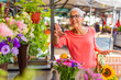 © Dragana Gordic - Senior Woman buys flowers in the market. Senior woman looking for flowers at outdoors market. Woman at farmers market with flowers. Beautiful mature woman selecting flowers