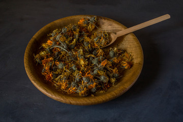 Dried marigold flowers in a wooden plate