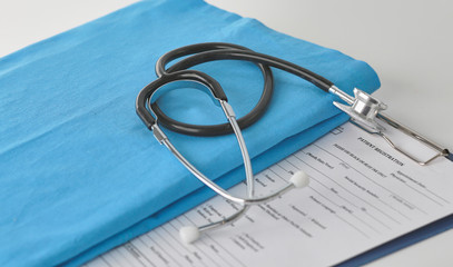 Doctor's workspace working table with patient's discharge blank paper form, medical prescription, stethoscope on desk