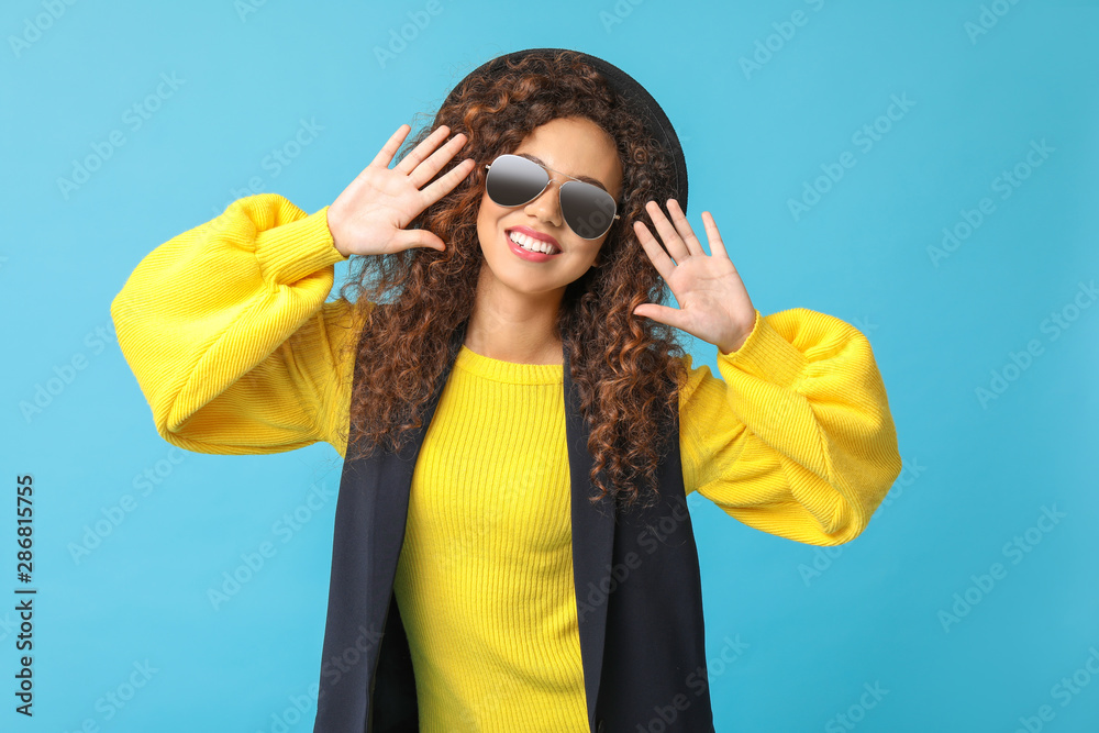 Stylish African-American woman on color background