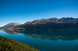 Fototapeta Natura - Amazed nature scenic landscape of invisibly mountain, clear blue sky reflection in turquoise lake, popular view point on the way to Glenorchy, South New Zealand.