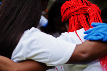 group of happy african volunteers hugs in park. africa volunteering, charity, people and ecology con