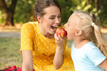 Canvas Print - Happy mother and her little daughter at picnic in park