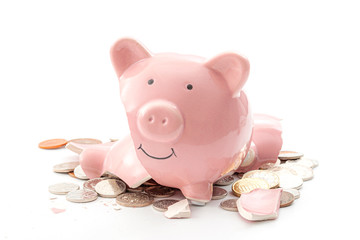 Break the bank, economic downturn and bankruptcy concept theme with a broken piggy bank and scattered coins isolated on white background