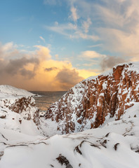 Wall Mural - snow covered red rocks on the barents sea in teriberka, kola peninsula, russia. a remote, but famous