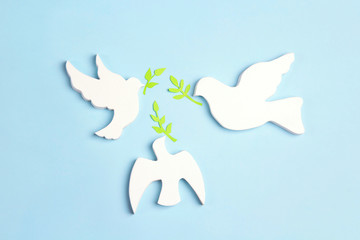 Wall Mural - Three doves of  peace with olive branches on a blue background.