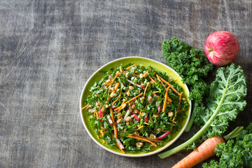 Wall Mural - Healthy cabbage kale salad with carrots, apple and walnut on wooden background