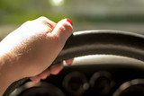 Fototapeta Lawenda - Woman driving a car with one hand holding the steering wheel