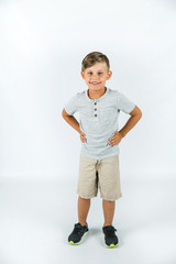 Little boy with autism standing on a white background feeling happy and smiling