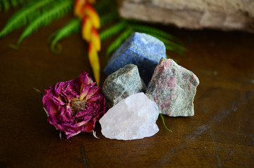 Wall Mural - Rough crystals in woman's hand with natural lighting. Raw Rose Quartz, Raw Lapis Lazuli, Raw Unakite, and Raw Ocean Jasper. Beautiful crystal display, crystals and plants, macro photography