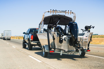 Semi-truck towing a  boat on the interstate, California