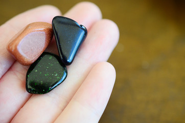 Wall Mural - Tumbled Red Goldstone, Blue Goldstone, and Green Goldstone! Sparkling healing crystals, magical witchy stones for reiki healing and energy work! Rainbow of tumbled stones natural lighting photoagraphy