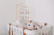 © paralisart - Beautiful interior of baby room. White crib with pillows and pink blanket in baby room.  pink bedding on bed against white wall