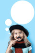 Funny girl in black beret, scarf and mustache on a stick on blue background