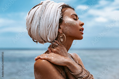 Fotografía close up portrait of beautiful young tribal woman in turban at blue sea and sky