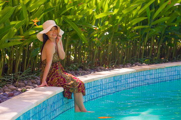 Wall Mural - lifestyle portrait of young beautiful and happy Asian Japanese tourist woman smiling cheerful and natural enjoying Summer holiday getaway at luxury tropical resort