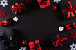 Top view of red and black christmas boxes on black background with copy space for text. black Friday composition.