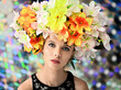 Portrait of a beautiful girl on a colored background with a wreath of flowers on her head. Beauty and brightness.