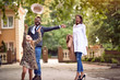 © luckybusiness - Mother and father with pupil having fun in park after school.