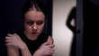 © motortion - Scared kidnapping victim looking at male silhouette entering room, mistreatment